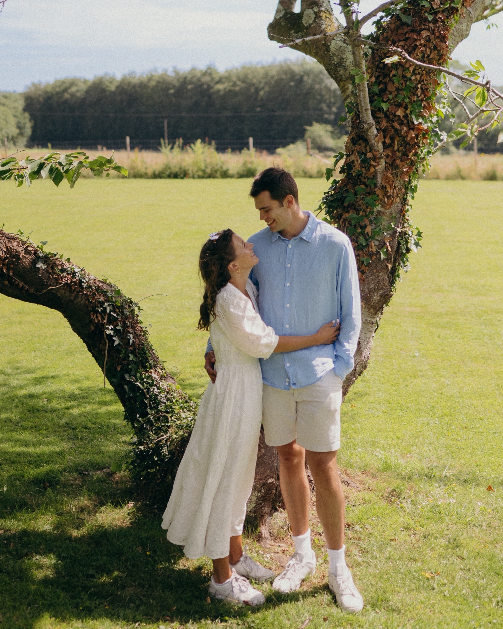 Vere and Ella under a tree at the edge of a field